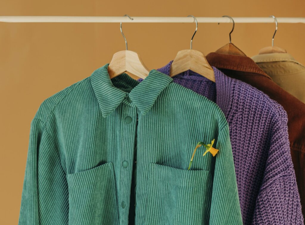 stylish colored shirts on hangers on a brown background