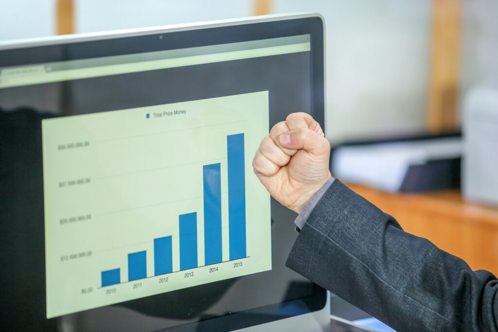 Closeup shot of a businessman holding his fist against a chart - success concept