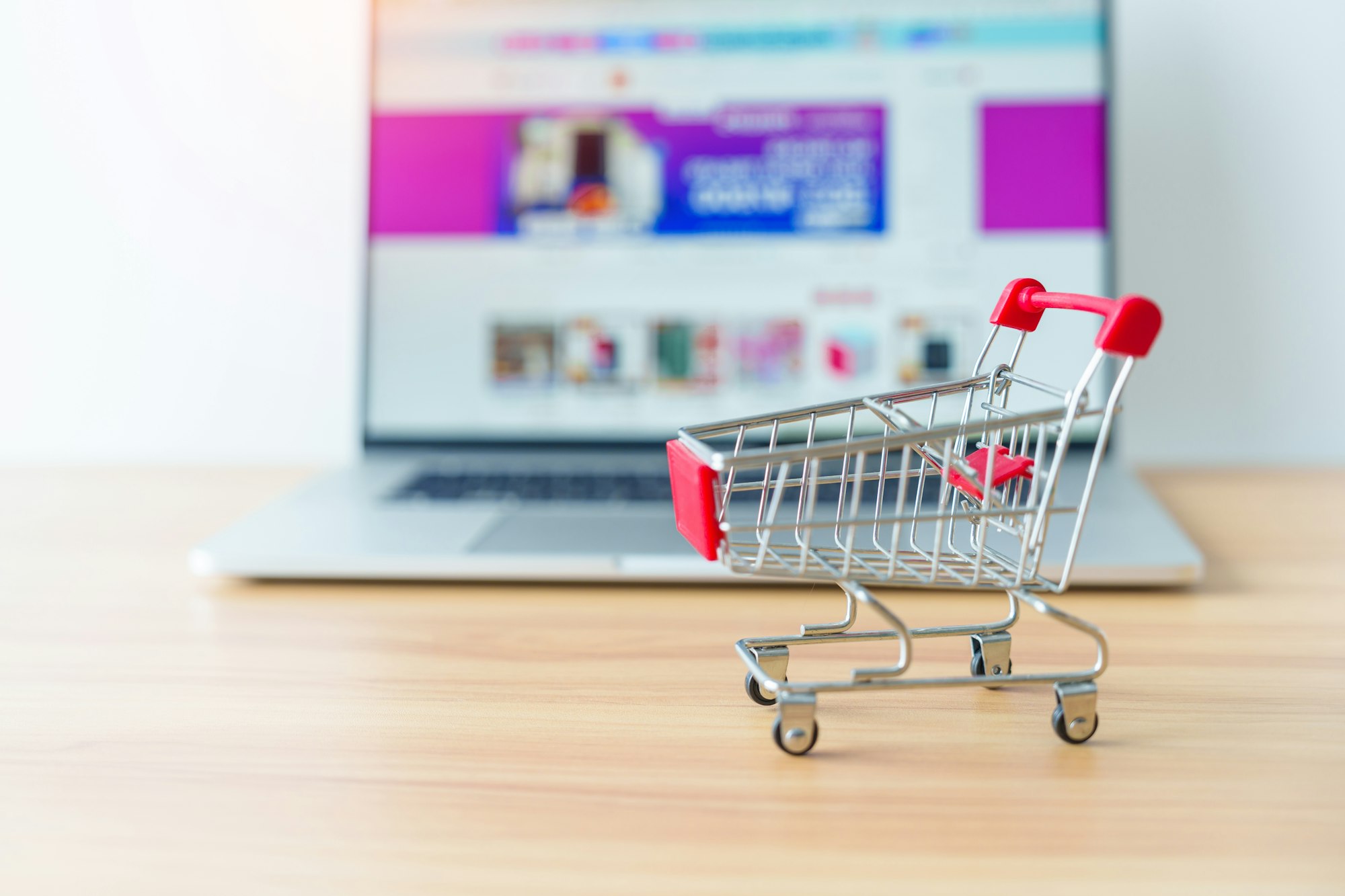 Shopping cart and laptop computer with marketplace website.