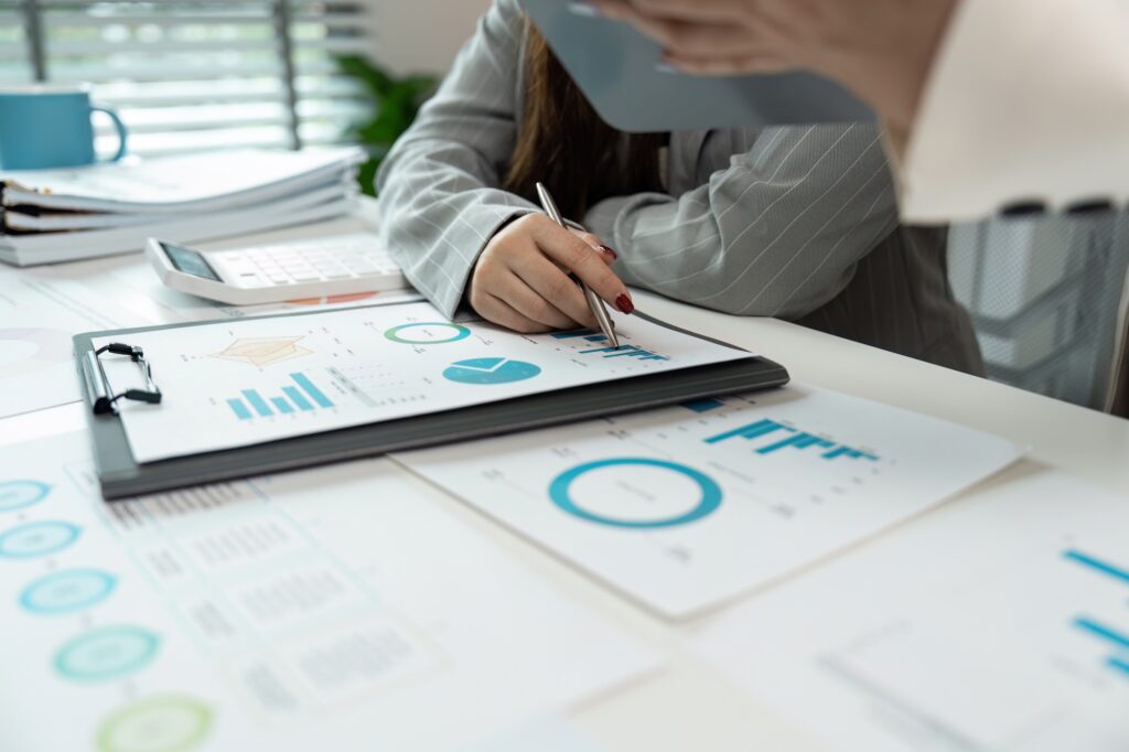 Business Meeting with Charts and Graphs on Desk, Analyzing Financial Data and Performance Metrics in