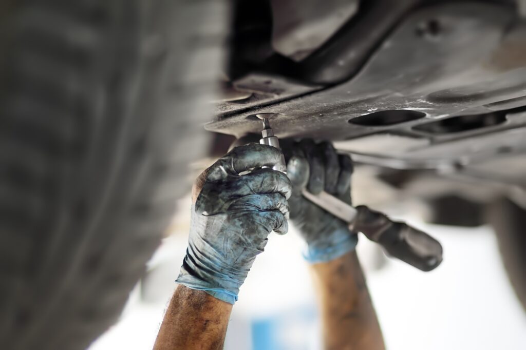 Man auto mechanic repairs car in auto service station