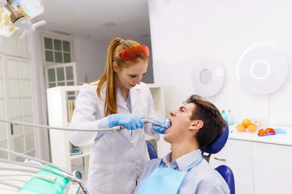 Dentist using tool dental drill on patient