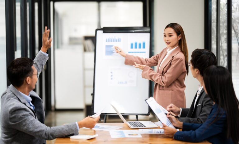 Confident Asian businesswoman with financial or marketing charts on a board to presentation,